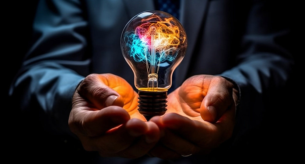 Colour light bulb held in hands representing the business concept of ideation and Strategic Demand Management